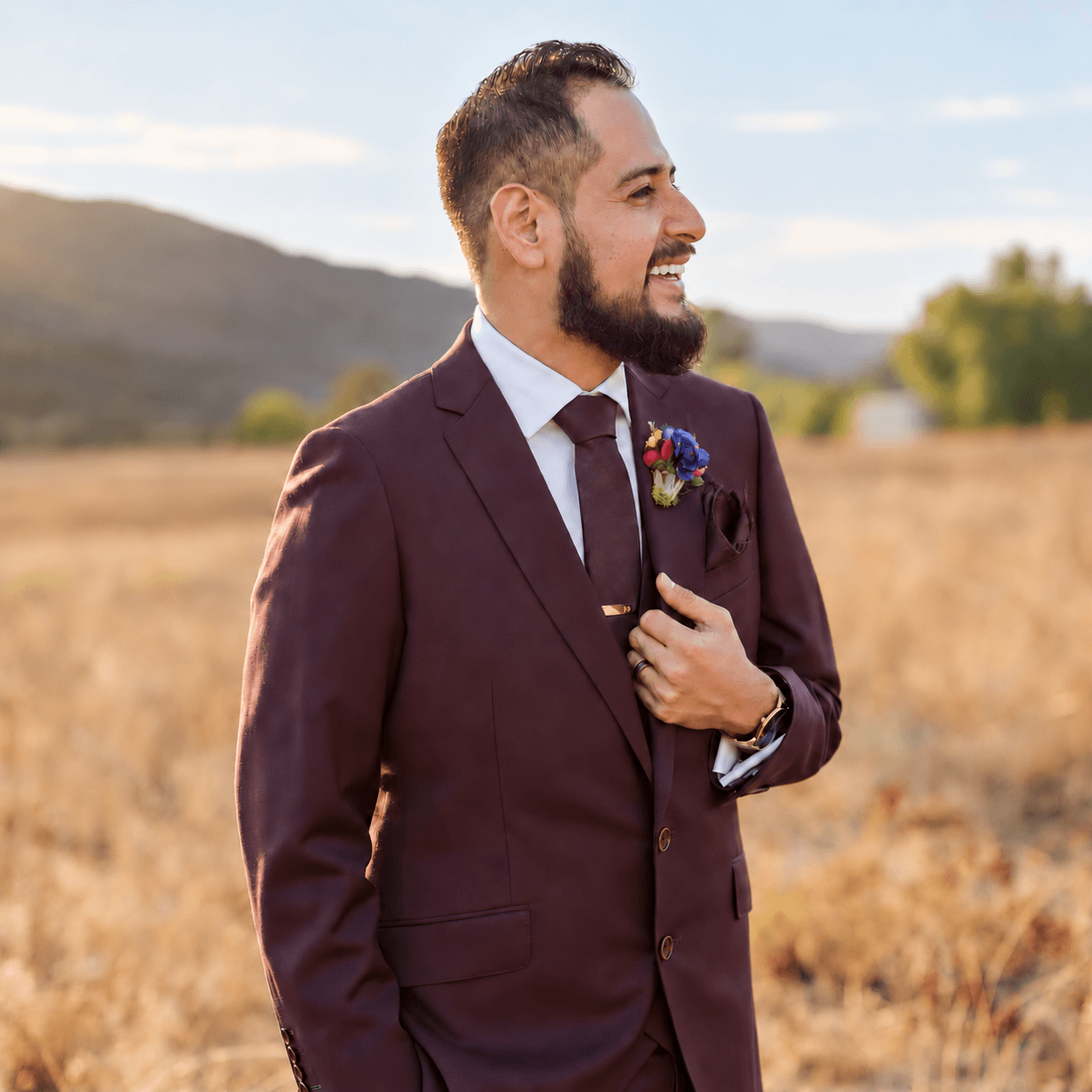 Brandon in a field wearing a suit and tie